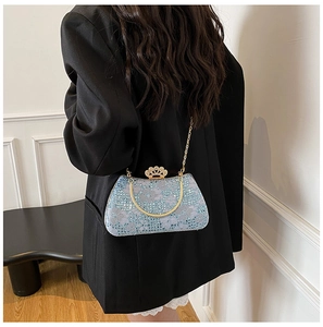 Detail of light blue sequin evening bag with gold crown clasp and elegant chain strap