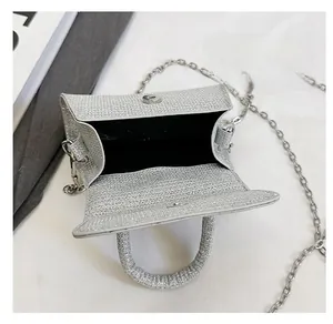 Detail view of silver sequin handbag showing black inner lining and magnetic snap closure