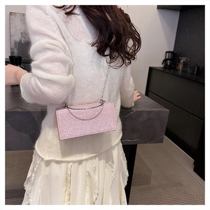 Pink sequin evening bag shown on model with sparkling finish and silver chain strap