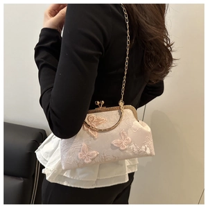 Detail of floral butterfly embroidery on vintage-style crossbody bag with gold chain strap