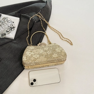Detail of gold sequin evening bag with heart rhinestone buckle and metal ring handle