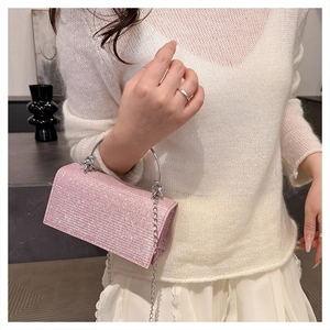 Close-up of pink rhinestone handbag with silver metal ring handle and chain strap