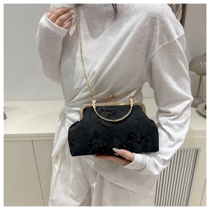 Détail d'une pochette vintage en dentelle noire avec papillons 3D et bandoulière dorée