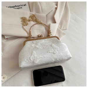 Detail of white lace shell bag featuring 3D butterfly appliques and golden metal handle