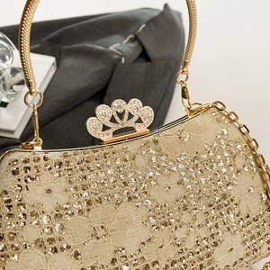 Close-up of champagne gold evening bag with crown clasp and intricate lace sequins