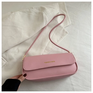 Detail of pink faux leather baguette bag with 'FASHION & BAGS' text on white fabric