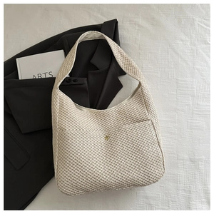 Detailed view of beige woven knit shoulder bag with gold clasp and thick texture