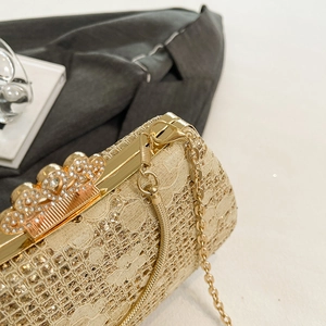 Detailed close-up of champagne lace evening bag with sequined texture and diamond clasp