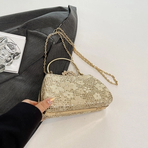 Close-up of golden sequin evening bag with sparkling floral pattern and crystal clasp
