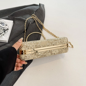 Detail of luxury champagne gold clutch bag with lace patterns and shimmering rhinestones