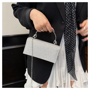 Close-up of sparkling silver rhinestone evening bag with metallic handle and chain strap