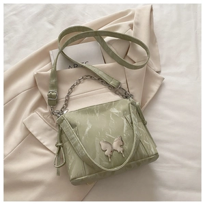 Detail of light green marble texture bag featuring a silver metal butterfly buckle and chain