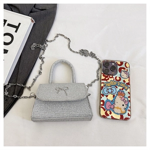 Close-up of sparkling silver bow handbag with sleek metal chain and textured finish