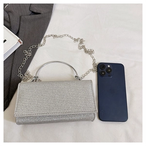 Detailed macro of silver glitter texture and silver ring handle on the chain crossbody bag