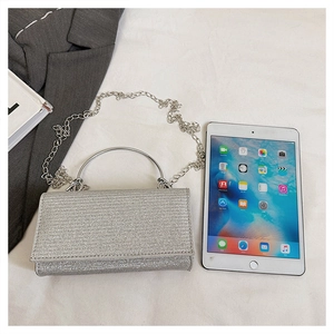 Detailed view of silver sequin bag with metal ring handle and sparkling glitter texture