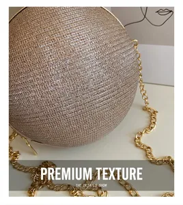 Dettaglio macro della borsa da sera sferica color oro con trama glitter e catena