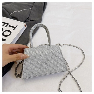 Detail of silver glitter mini handbag with trapezoid structure and chain strap