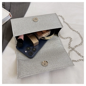 Detailed interior view of silver sequin evening bag showing phone and lipstick storage
