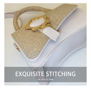 Détail du fermoir floral en métal et texture pailletée dorée sur un sac à main en cuir blanc