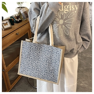 Close-up of floral print linen tote bag with cream cotton handles in a lifestyle setting