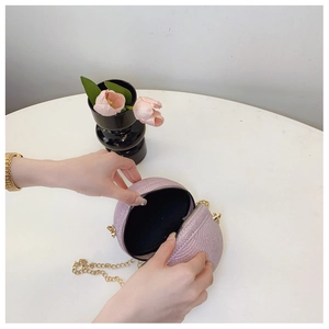 Detailed view of pink glitter sphere clutch bag with gold chain and interior lining