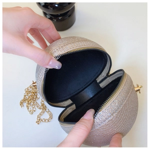 Detailed top view of a gold sequin spherical clutch with chain strap and metal clasp
