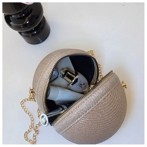 Macro shot of open champagne glitter ball bag showing capacity for phone and cosmetics