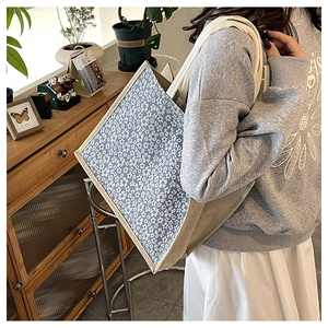 Detail shot of the blue floral canvas tote bag showing textured linen sides and strap