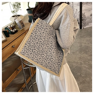Detailed side view of floral canvas tote bag with daisy pattern and shoulder straps