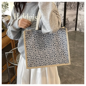 Detail of floral print burlap tote bag with rustic woven straps and grey canvas fabric