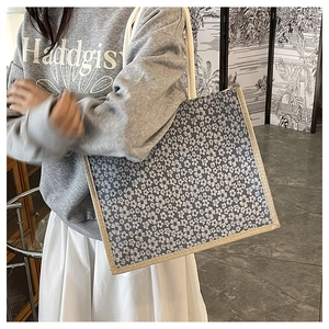 Detail view of woven jute edge and navy floral canvas material on a large tote bag