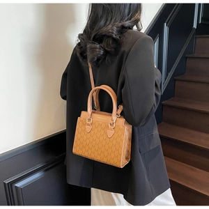 Détail de vue arrière d'un sac cabas marron à carreaux avec lettrage doré