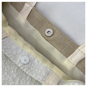 Close-up of linen tote bag featuring a magnetic metal clasp and floral textured lining