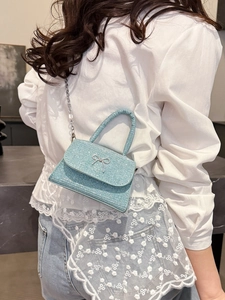 Sparkly light blue bow mini handbag with silver chain strap for women shown on model
