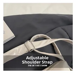 Close-up of adjustable shoulder strap with silver metal buckle on cream PU leather bag