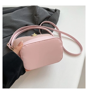 Détail du sac seau rose avec fermoir doré et panneau à texture tissée élégant