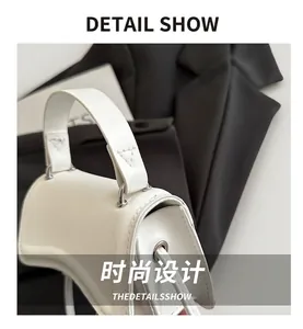 Detail view of white hourglass handbag with matte leather texture and silver buckle