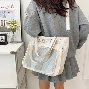 Japanese style white canvas ita bag with mesh pocket and heart metal buckle shown on model