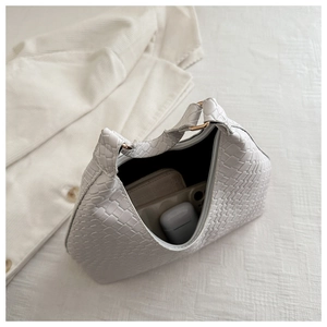 Detailed close-up of a white woven shoulder bag showing texture and interior capacity