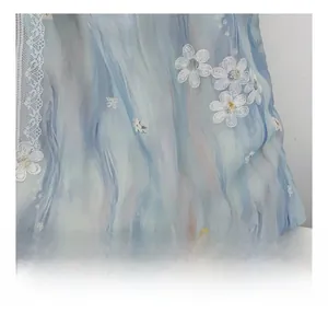 Macro detail of blue floral embroidery and delicate lace trim on the canvas fabric