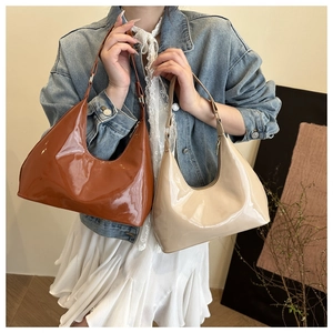 Detailopname van hobo-tassen van lakleer in karamel en beige met glanzende afwerking