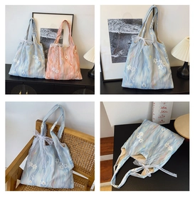 Close-up of floral embroidery and lace bow details on watercolor canvas tote bag