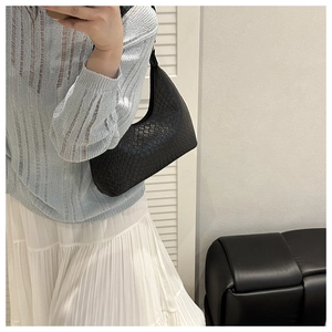 Detail of black woven leather hobo shoulder bag with textured square grid pattern