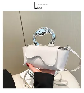 Detailed close-up of white crossbody bag featuring unique silver liquid metal U-shaped handle