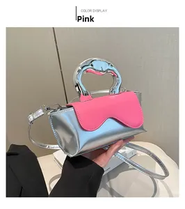 Detail view of silver mini bag with pink scalloped flap and chunky metallic handle