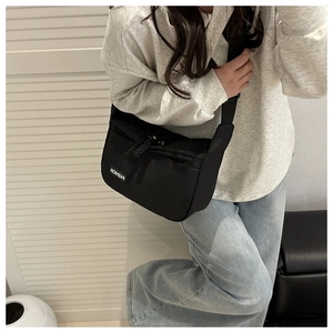 Detailansicht der schwarzen Fashion Umhängetasche mit Logo-Patch und robustem Nylon-Gewebe