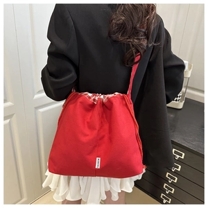 Detailed back view of a vibrant red canvas crossbody bag with white fashion tag