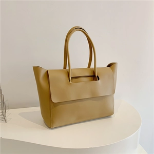 Detail view of the beige tote bag with a minimalist flap cover and sturdy double handles