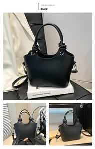 Detail of black leather bucket bag with silver lettering and knotted handle decor