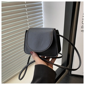 Close-up of black lychee grain leather mini crossbody bag with a slim strap